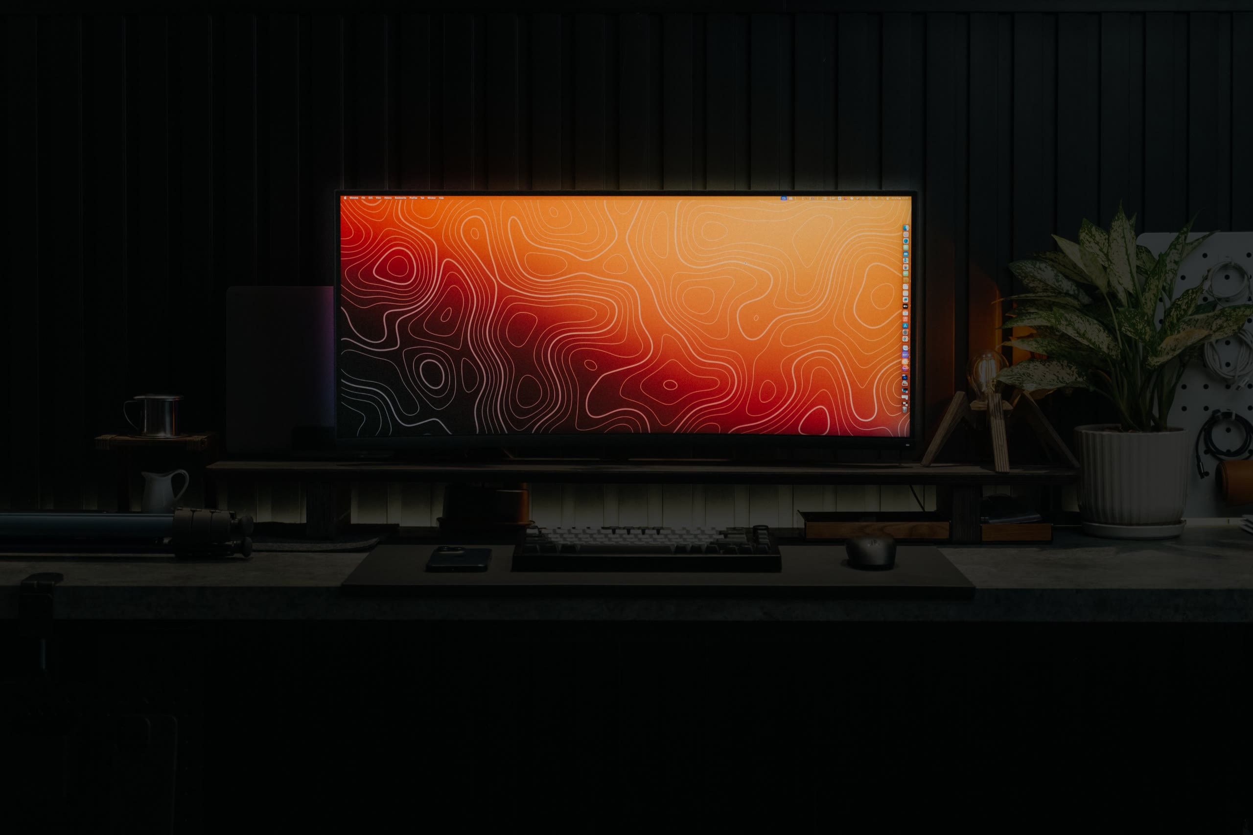 An ultrawide monitor glowing on a dark desk setup