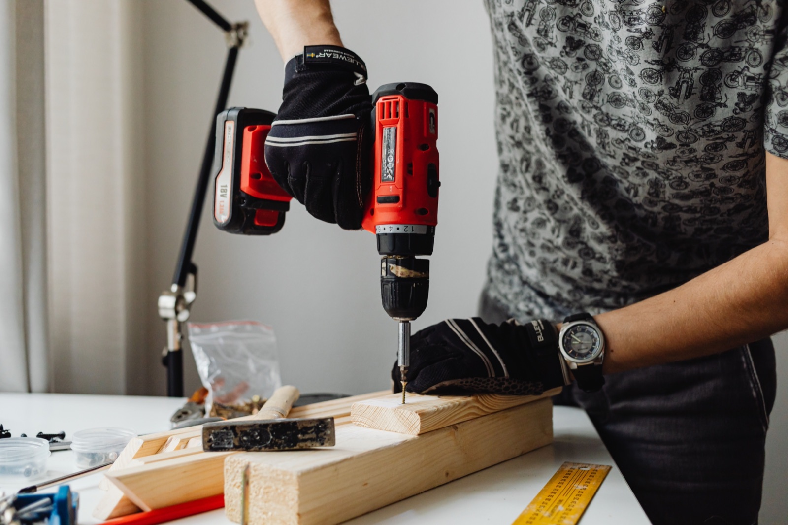 A tradesman driving a screw into timber with a cordless drill